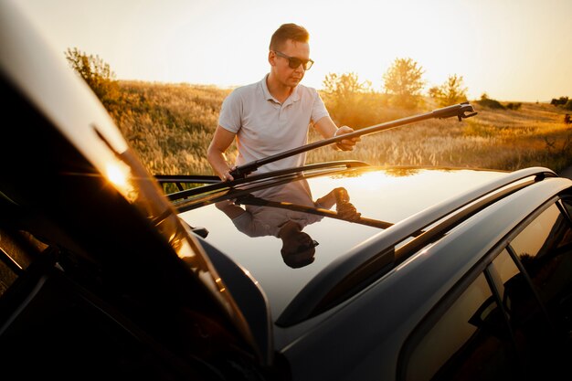 Young man setting up the car roof