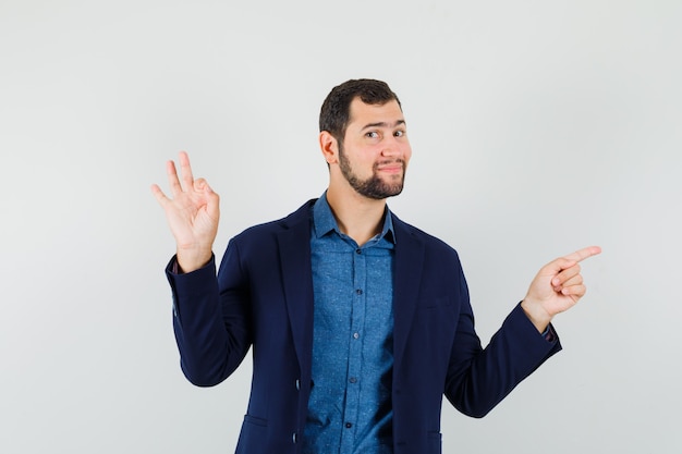 Young man in shirt, jacket showing ok gesture