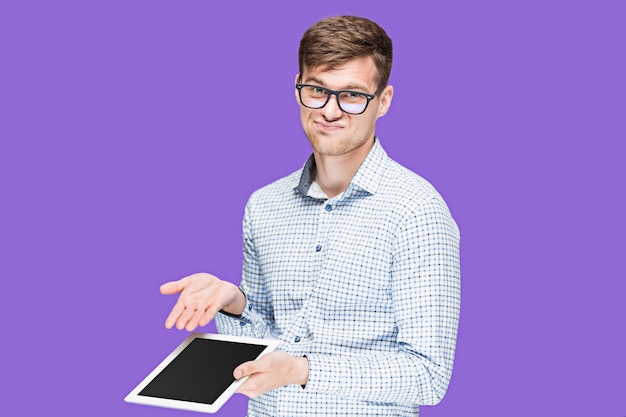 young man in a shirt working on laptop on purple