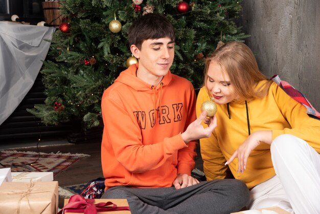 Молодой человек показывает Рождественский бал своей девушке в интерьере Рождества.