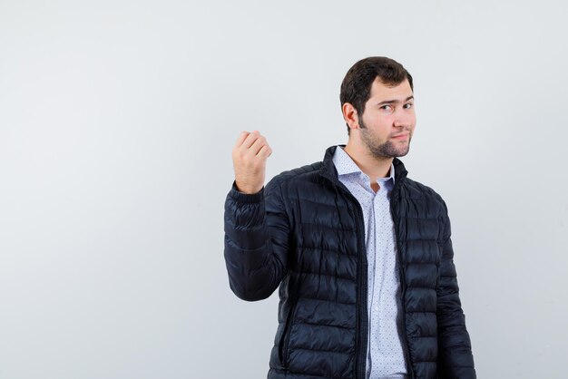 Young man showing his fist on white background