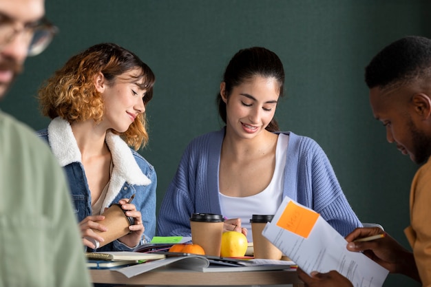 Free photo young man showing his friends his notes during study session