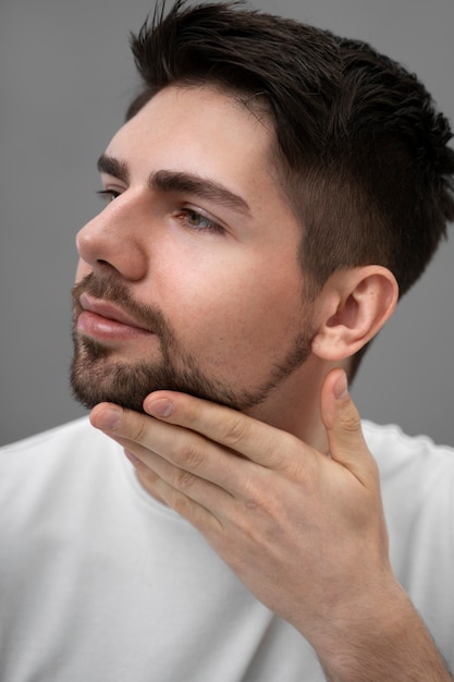 Free photo young man showing his glowing skin