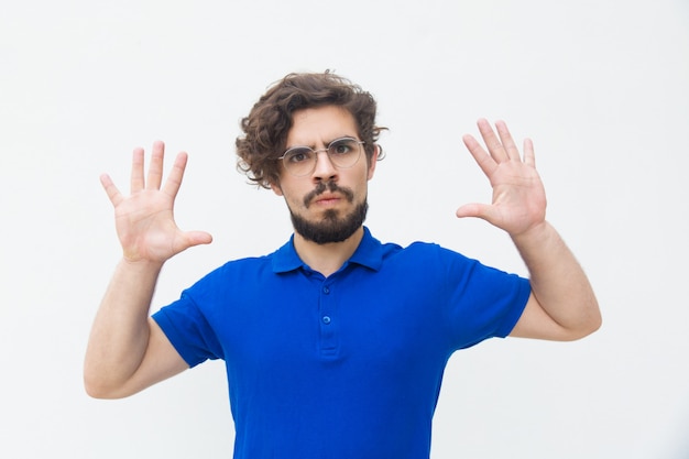 Young man showing palms as stop gesture.