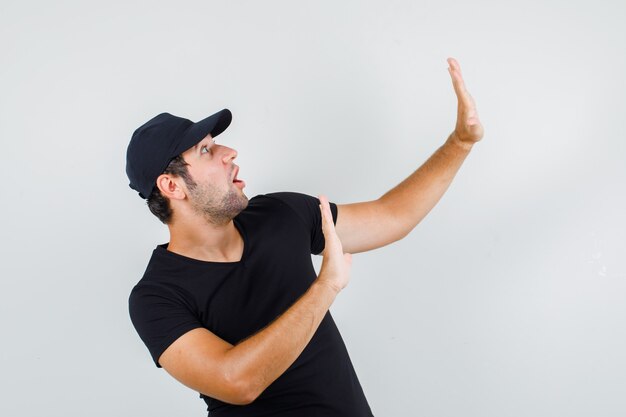 Young man showing refusal gesture in black t-shirt