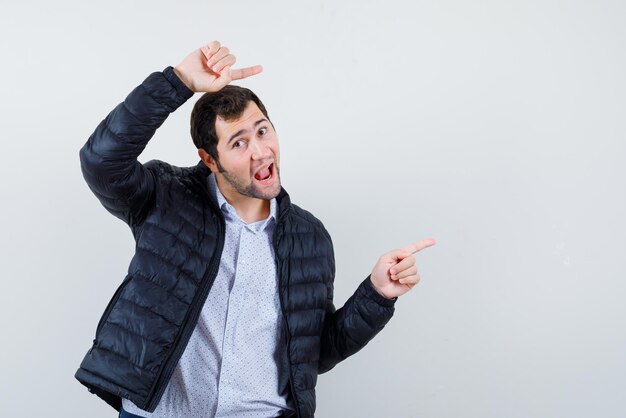 Young man showing the right with his fingers on white background