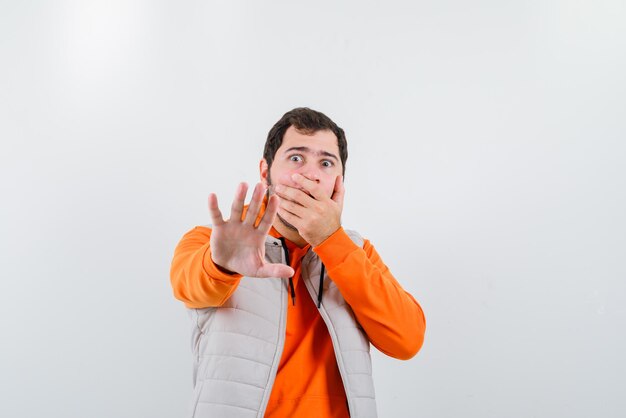 Young man showing a stop hand gesture on white background