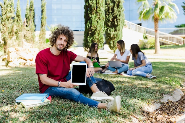 Young man showing tablet to camera