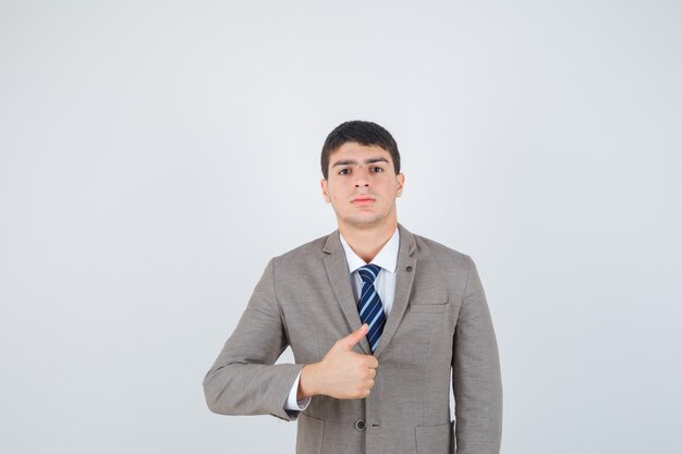 Молодой человек показывает палец вверх в строгом костюме