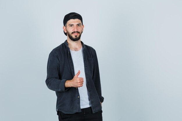 Young man showing thumbs up and looking pleased