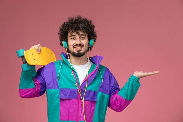 Free photo young man shows scate board and empty hand