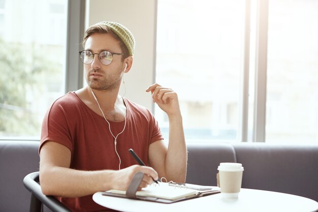 音楽を聴くカフェに座っている若い男