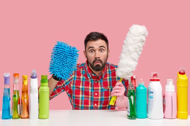 Young man sitting next to cleaning products