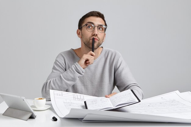 Young man sitting at desk and doing paperwork