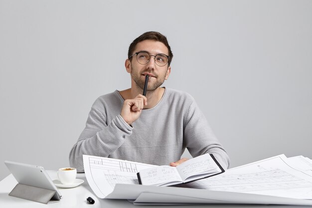 Young man sitting at desk and doing paperwork