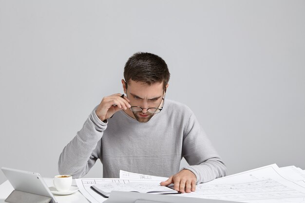 Young man sitting at desk and doing paperwork