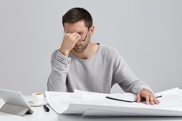 Young man sitting at desk and doing paperwork