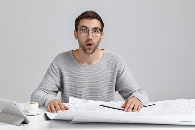 Young man sitting at desk and doing paperwork