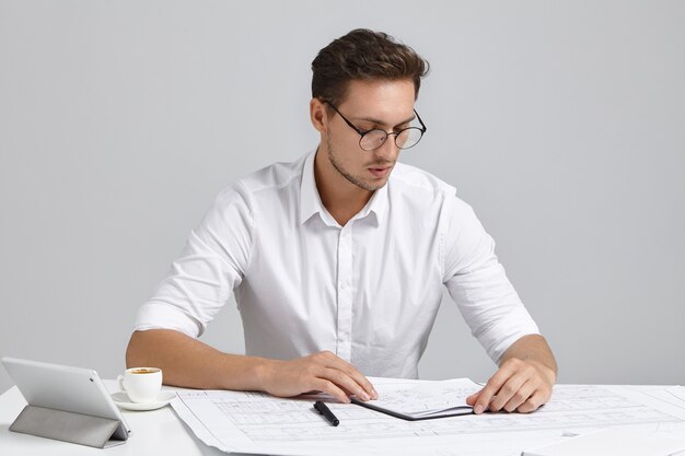 Young man sitting at desk and doing paperwork