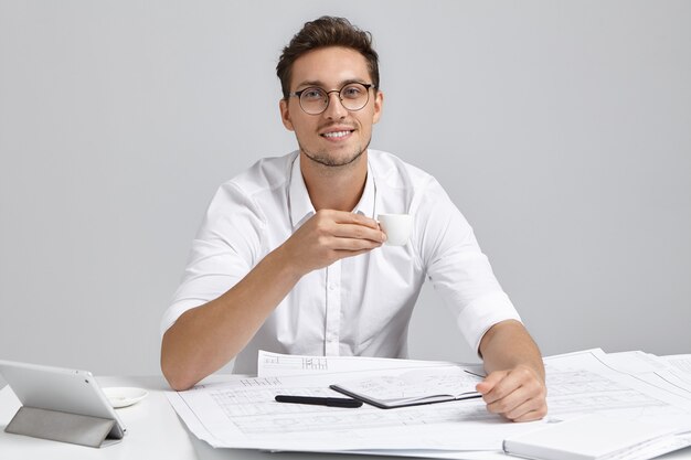 Young man sitting at desk and doing paperwork