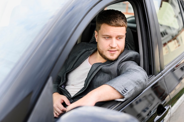 Young man sitting on the drivers seat