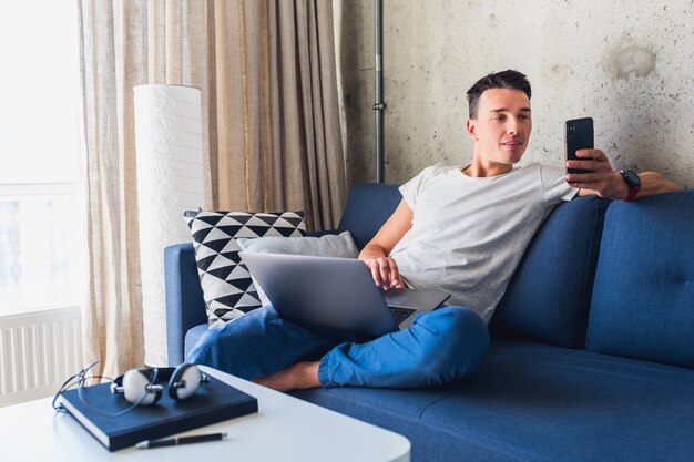 온라인으로 작업하는 집에 앉아 젊은 남자