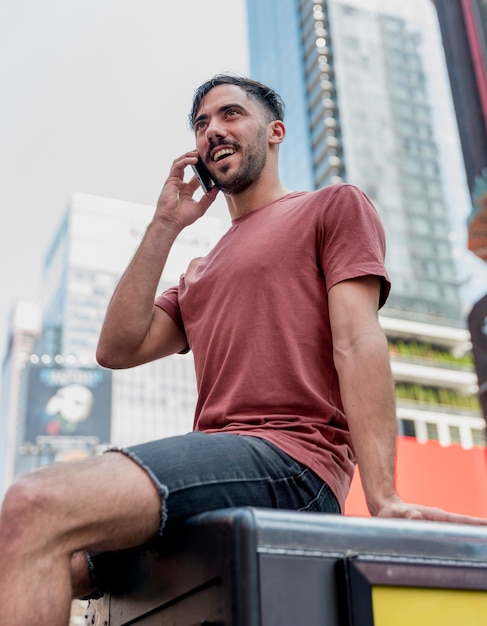 Free photo young man sitting and talking over phone