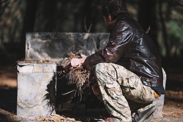 Free photo young man sitting with foliage