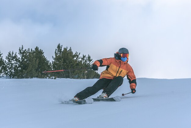 Grandvaliraスキーリゾートのピレネー山脈でスキーをする若い男