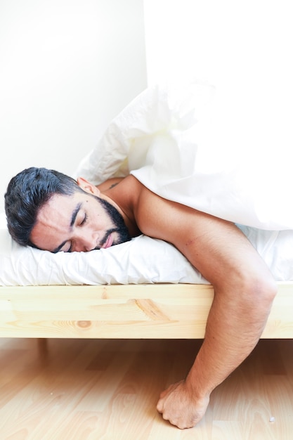 Young man sleeping on bed