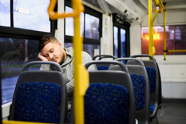 Giovane che dorme sul sedile dell'autobus