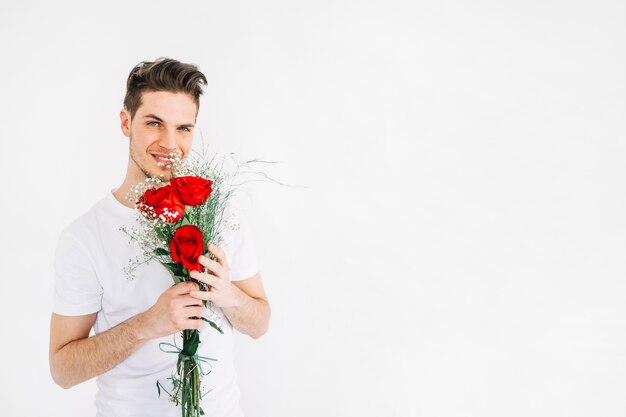 Young man smelling beautiful flowers