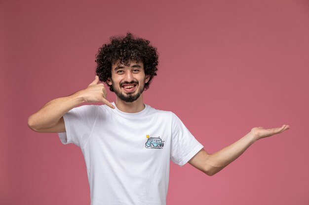 young man smiling and demonstrating call me gesture