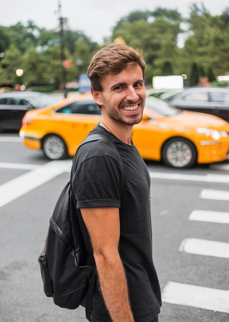 Young man smiling near pedestrian crossing