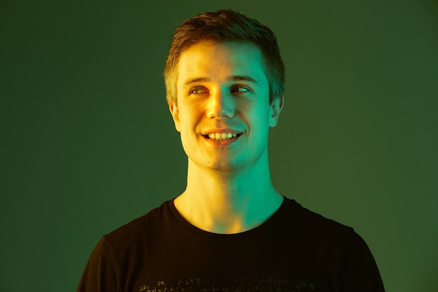 Young man smiling with neon light