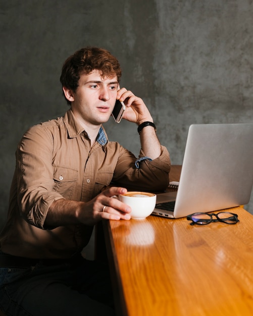 Free photo young man speaking on the phone in the office