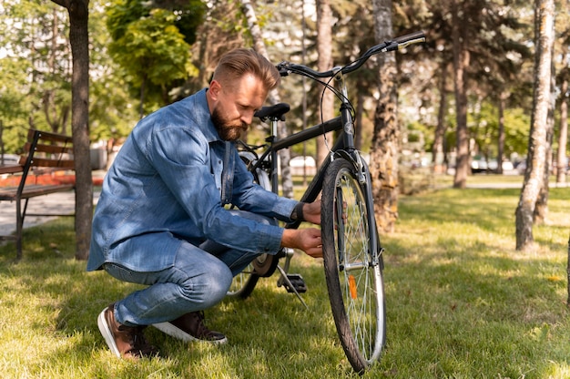 Free photo young man spending time outside with his bike