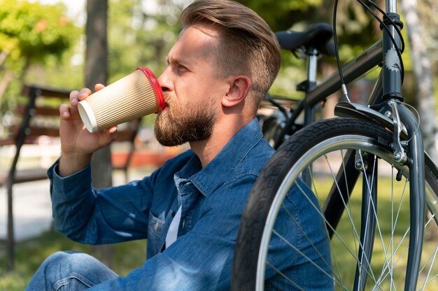 彼の自転車で外で時間を過ごす若い男