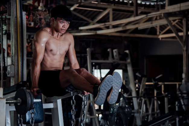 Молодой человек в спортивной одежде упражнения в тренажерном зале