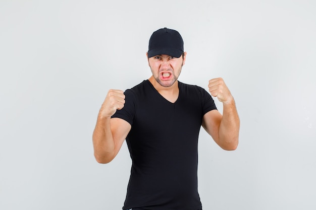 Free photo young man standing on in boxer pose in black t-shirt