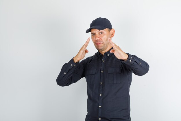 Young man standing in fighting stance in black shirt and looking confident