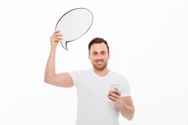 Young man standing isolated holding speech bubble
