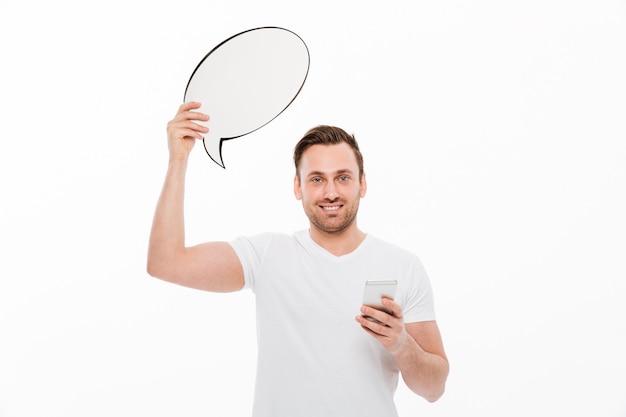 Young man standing isolated holding speech bubble