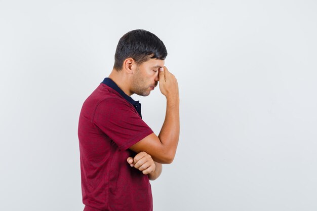 Young man standing in thinking pose in t-shirt and looking indecisive. .