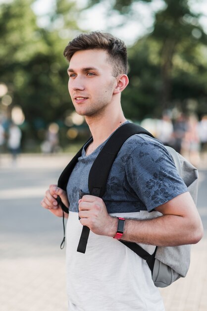 バックパックで立っている若い男