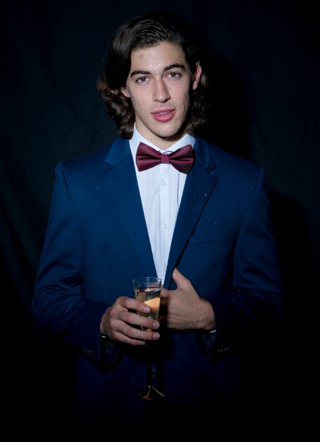 Young man standing with champagne glass 