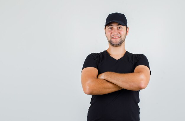 Young man standing with crossed arms in black t-shirt