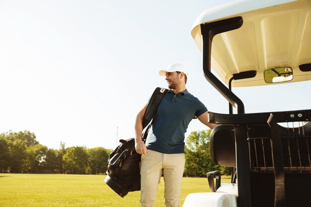 Young man standing with golf bag