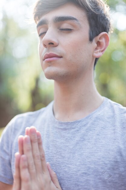 Young man standing in yoga pose outdoors