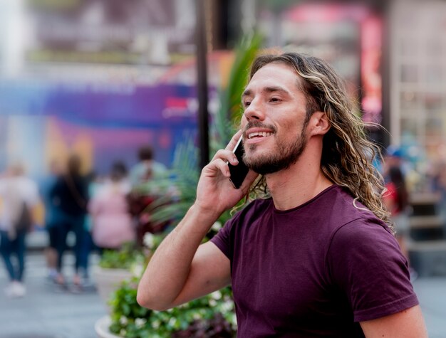 Молодой человек на улице разговаривает по телефону